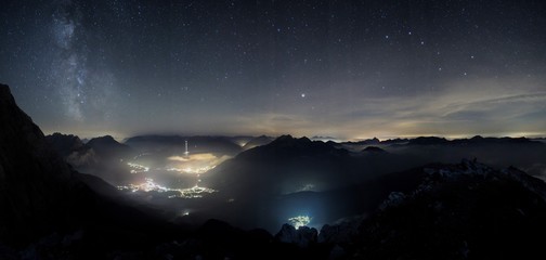 Fototapeta premium Milky way shot from high above, with the still illuminated city