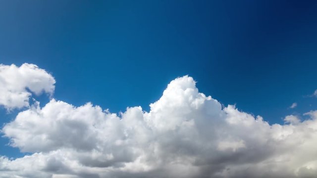 Clouds running across the blue sky. 4K timelapse.