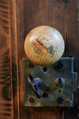 Old lock and knob on brown wooden door. Vertical image.