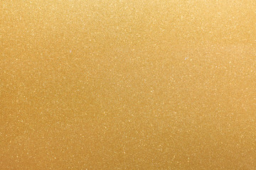 Golden glitter orange yellow surface with blinking white irregular spots, copy space background.