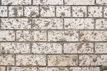 A wall of white brick spattered with mud.