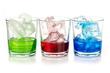 green, blue and red drink with ice cubes on white background