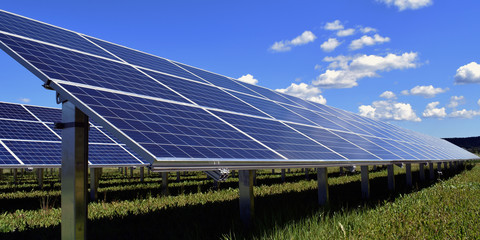 Solar panel photovoltaic close up. Panorama side view with beautiful blue sky with a few small...