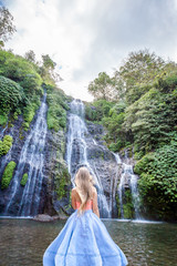 Young woman in front of Banyumala twin waterfalls
