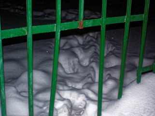 footprints in the snow from a hole in the fence