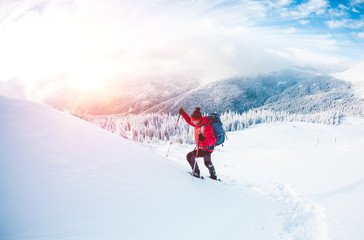 A man in snowshoes in the mountains.