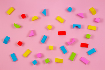 Fototapeta na wymiar Colorful wooden building blocks on pink background