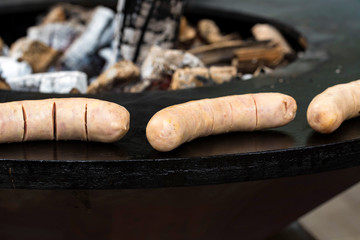 Roasting sausages on black griling pan close