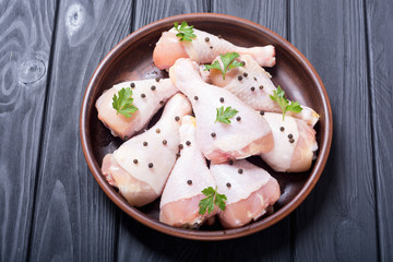 Raw chicken legs with spices and parsley