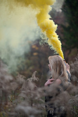 Girl - blonde with a smoke bomb side view