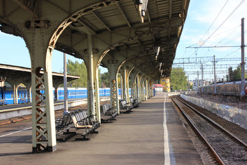 Empty Outdoor Platform with Vintage Seats at Old City Train Station with No Passengers on Summer Day. Vintage Architecture of Railway Station in St. Petersburg, Russia  