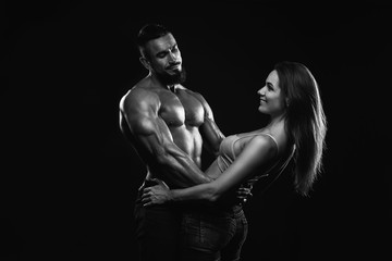Fototapeta na wymiar Fitness couple on a black background are in the studio. Black and white