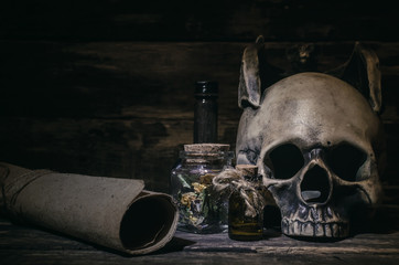 Magic potion and human skull on magic table background. Witchcraft concept.