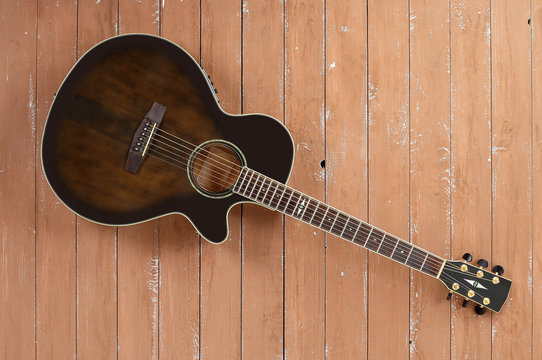 Musical instrument - Top view brown cutaway electric acoustic guitar wood background