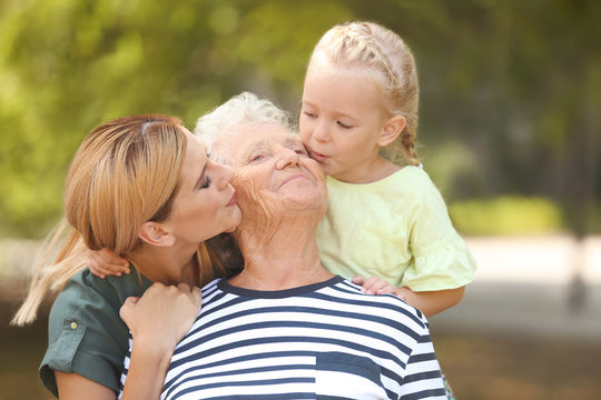 Woman with daughter and elderly mother outdoors