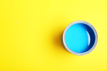 Paint can on yellow background, top view. Space for text