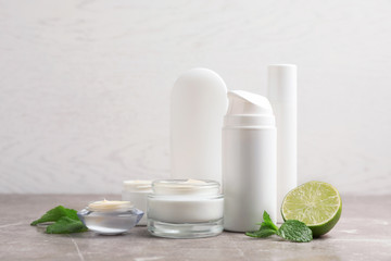 Jars with cream and bottles on gray table. Hand care cosmetics