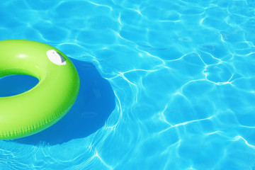 Inflatable ring floating in swimming pool on sunny day. Space for text