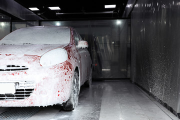 Auto covered with foam at car wash. Space for text