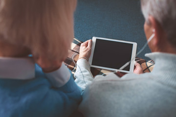 Close up of dark screen on the tablet. It is hold by mature man.