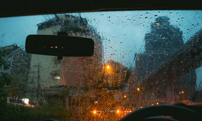 rain drop on car window and blur background,city