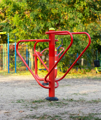Fototapeta na wymiar red iron sports simulator in a public park