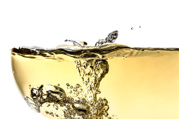 Splash white wine in glass with bubbles close-up macro texture isolated on top on white background. Wave of white wine with beautiful fizz.