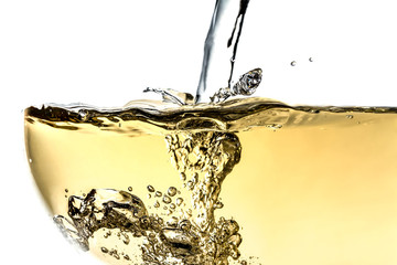 Splash white wine in glass with bubbles close-up macro texture isolated on top on white background. Wave of white wine with beautiful fizz.