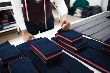 Young bearded tailor working on new cloting design