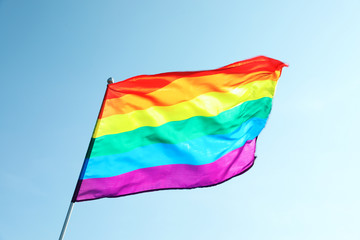 Rainbow gay flag against blue sky. LGBT concept