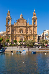 Fototapeta na wymiar Msida, Malta. The picturesque facade of the baroque church of St. Joseph on the embankment, 1889