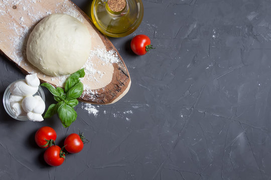 Raw pizza ingredients on the grey background with copy space, you can put your image or inscription on the right