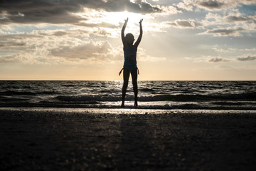 kid jumping silhouette sunset beach