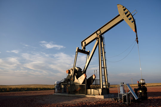 A single crude oil pump jack, rural fields and blue sky, Powder River Basin, Wyoming