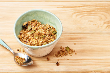 Homemade granola in a bowl on a wooden table.