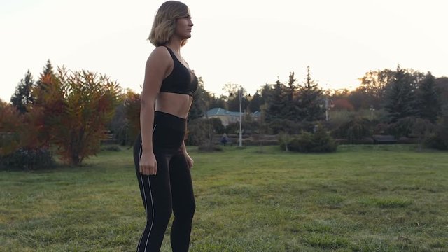 Sporty woman doing sit uo exercises outdoors in the park.