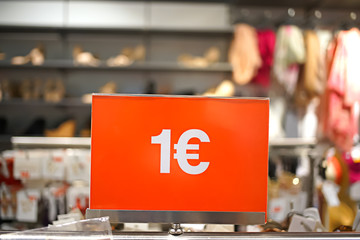 price one euro - inscription on a red background on the price tag in a clothing store during the sale