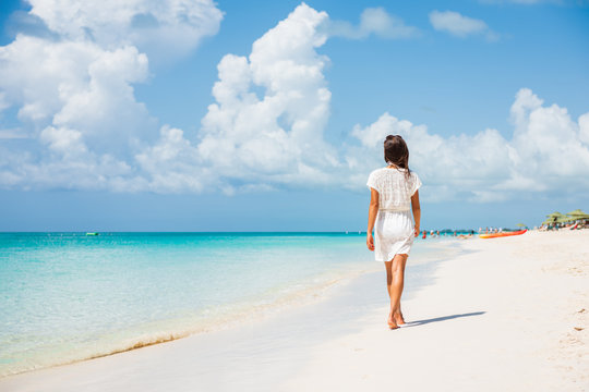 Caribbean beach luxury vacation summer holiday woman walking on perfect white sand tourist destination.