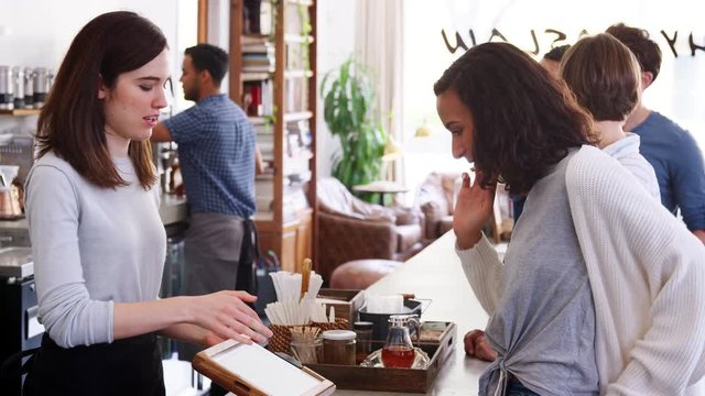 Young customers queuing to order and pay at a coffee shop