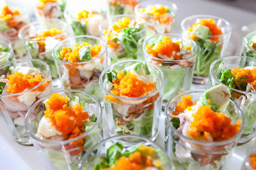 Party catering Cocktail food on a mini dish and tiny glass bowls.