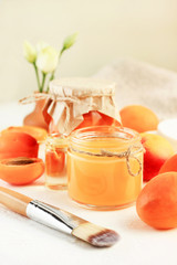 Homemade face mask with fresh ripe orange apricot, natural fruit skincare. Jar of mask with application brush. 