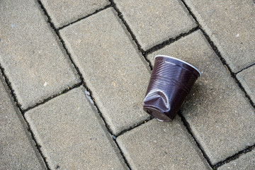 Plastic cup crushed on street in city