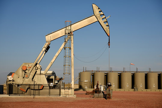 Crude oil well site pump jack and production storage tanks in the Niobrara shale of Wyoming, USA