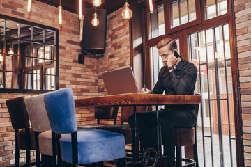 Businessman writing notary during mobile phone conversation