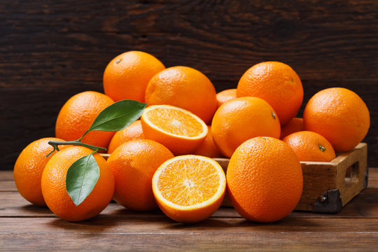 fresh orange fruits in a box on wooden table