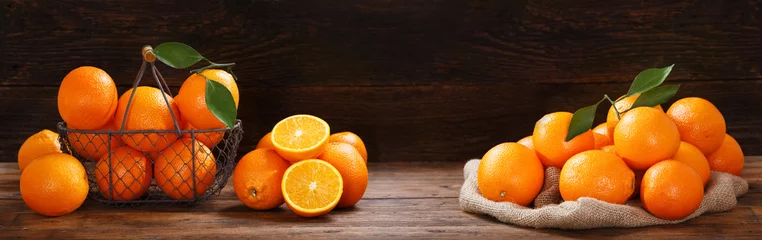 Foto auf Acrylglas frische orange Früchte auf Holztisch © Nitr