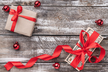A Christmas gift, money, Xmas items, on a wooden background. Top view.