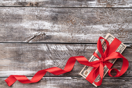 Christmas background of old wood, money embellished with red slack. Top view.