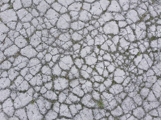 The texture of old asphalt with cracks.

