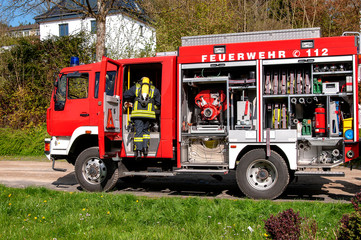 Feuerwehrfahrzeug mit aussteigendem Atemschutzgeräteträger an einer Einsatzstelle